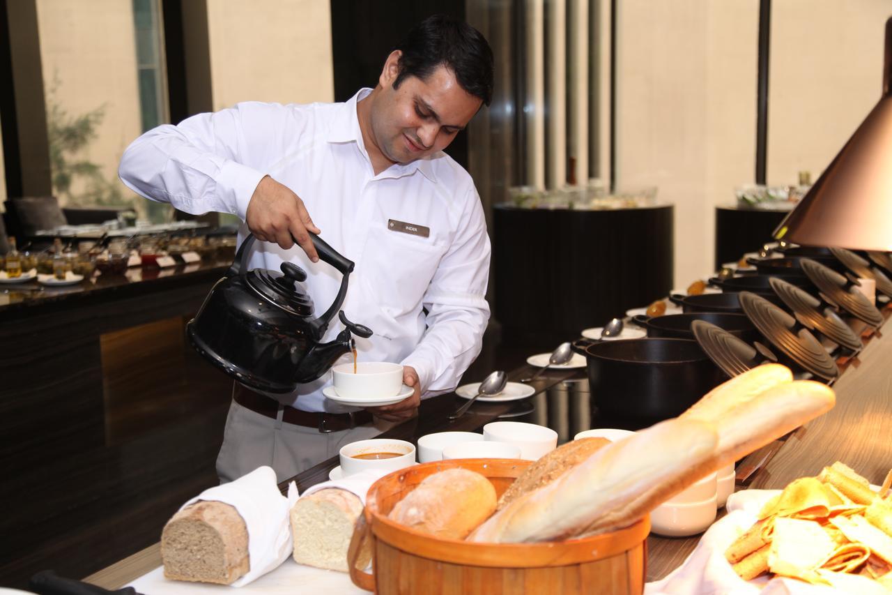 Roseate House New Delhi Hotel Bagian luar foto A waiter serving masala tea